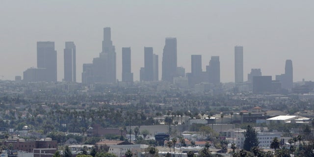 The skyline of downtown Los Angeles through a layer of smog is seen in the distance from a rooftop in Hollywood, California, May 31, 2006. (REUTERS/Fred Prouser/Files)