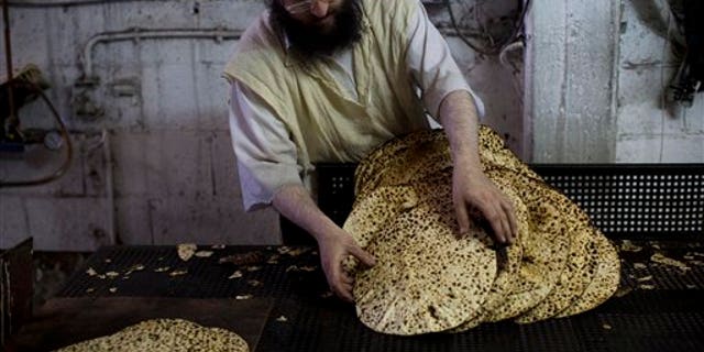 An Orthodox Jewish man prepares special matzoh, a traditional handmade Passover unleavened bread, at a bakery in Bnei Brak near Tel Aviv, Israel. Tuesday, March 31, 2015. (AP Photo/Oded Balilty)