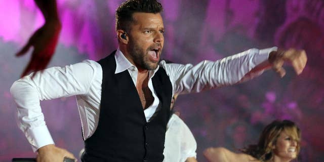 FILE - In this May 31, 2014 file photo, Ricky Martin performs during the opening ceremony of the Life Ball in front of City Hall in Vienna, Austria. Televisa announced Thursday, July 24, 2014, that Martin will be a coach in the fourth season of “La Voz...Mexico,” or "The Voice...Mexico," which premieres September 7. The Puerto Rican singer was previously a coach on the Australian version of “The Voice.” (AP Photo/Ronald Zak, File)