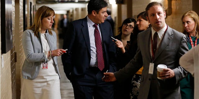 US Representative Raul Labrador talks to reporters gathered to ask members about House Majority Leader Eric Cantor's Republican primary election defeat in a hallway of the U.S. Capitol in Washington on June 11, 2014.