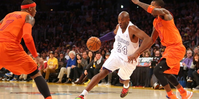 Kobe Bryant #24 of the Los Angeles Lakers dribbles to the basket against J.R. Smith #8 and Carmelo Anthony #7 of the New York Knicks in the first half during the NBA game at Staples Center on December 25, 2012 in Los Angeles, California.(Photo by Victor Decolongon/Getty Images)