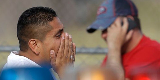 April 16, 2012: The brother of a murder victim reacts at a police road block near the home site where her body was found with her daughter's in Las Vegas.