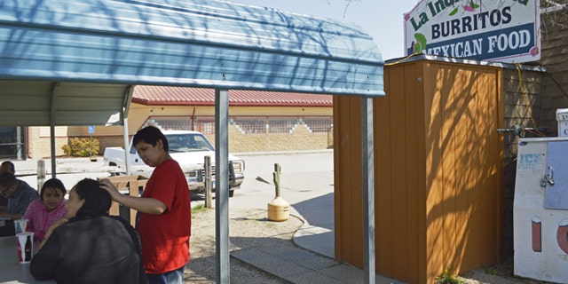 FILE - In this May 1, 2015 file photo, customers eat outside La India Bonita Mexican Restaurant in Kyle, S.D., on the Pine Ridge Indian Reservation. The population growth of U.S. Latinos is slowing thanks to lower immigration and declining birthrates, although states like North Dakota, South Dakota, and Tennessee are seeing Latino population spikes, according to a Pew Research Center study released Thursday, Sept. 8, 2016. (AP Photo/Russell Contreras, File)
