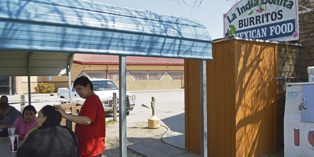 FILE - In this May 1, 2015 file photo, customers eat outside La India Bonita Mexican Restaurant in Kyle, S.D., on the Pine Ridge Indian Reservation. The population growth of U.S. Latinos is slowing thanks to lower immigration and declining birthrates, although states like North Dakota, South Dakota, and Tennessee are seeing Latino population spikes, according to a Pew Research Center study released Thursday, Sept. 8, 2016. (AP Photo/Russell Contreras, File)