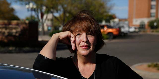 In this Oct. 4, 2016 photo, Donald Trump supporter Mary Celeste Madrid stands by her car, in Pueblo, Colo. A longtime Democrat and Obama voter who changed her registration to Republican last year over the GOP's support for gun rights and opposition to abortion, Madrid says she's also had to endure family battles over her support for Trump. (AP Photo/Brennan Linsley)