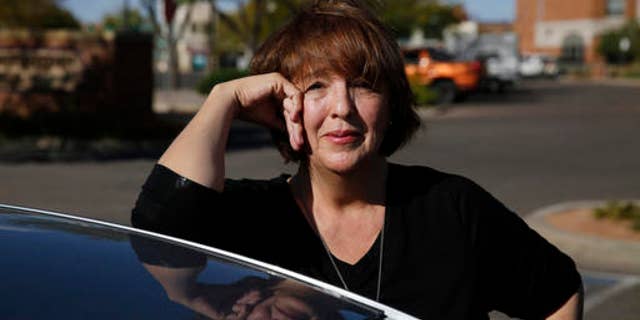 In this Oct. 4, 2016 photo, Donald Trump supporter Mary Celeste Madrid stands by her car, in Pueblo, Colo. A longtime Democrat and Obama voter who changed her registration to Republican last year over the GOP's support for gun rights and opposition to abortion, Madrid says she's also had to endure family battles over her support for Trump. (AP Photo/Brennan Linsley)