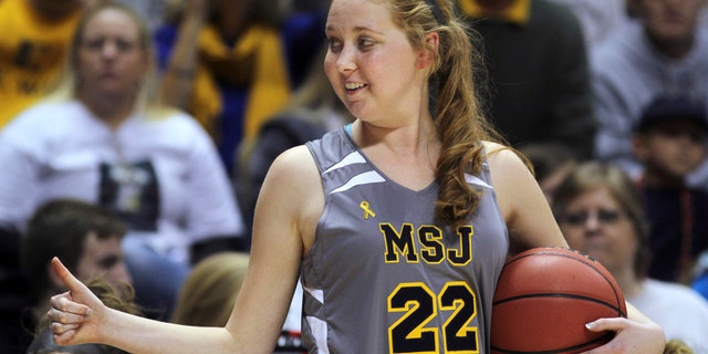 Nov. 2, 2014: In this file photo, Mount St. Joseph's Lauren Hill gives a thumbs-up as she holds the game ball during her first NCAA college basketball game against Hiram University at Xavier University in Cincinnati.