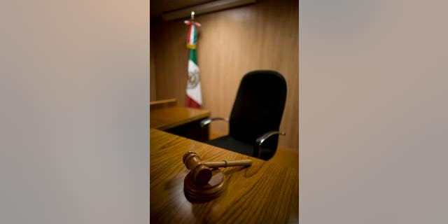 FILE - In this July 12, 2008 file photo, a gavel rests on the table of a model court room at Mexico's National Institute of Penal Sciences in Mexico City. The model courtroom has been used by students to prepare for the new legal system that will replace its closed proceedings with public oral trials in which suspects are presumed innocent, legal authorities can be held more accountable and equal justice is promised to all. Yet the decision of three Chihuahua state judges, under the new open oral trial system, to absolve the main suspect in the 2008 murder of a 16-year-old girl has put the country's U.S.-backed judicial reform on trial. (AP Photo/Dario Lopez-Mills, File)