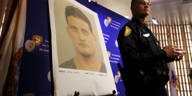 Tallahassee Police Department Public information officer David Northway reveals an image of Sigfredo Garcia, 34, during a press conference in Tallahassee, Fla., Thursday, May 26, 2016. Garcia is wanted for the murder of Florida State University law professor Dan Markel. Markel was killed in his Tallahassee home in July 2014. 