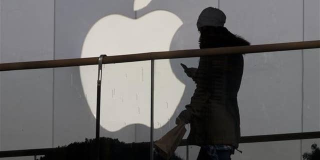 A woman walks past an Apple store in Beijing in this file photo. In dozens of leaked emails, women working at the company's headquarters in California complained of a sexism and gender harassment.