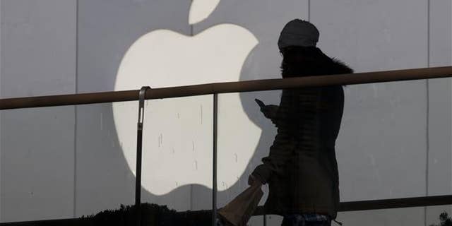 A woman walks past an Apple store in Beijing in this file photo. In dozens of leaked emails, women working at the company's headquarters in California complained of a sexism and gender harassment.