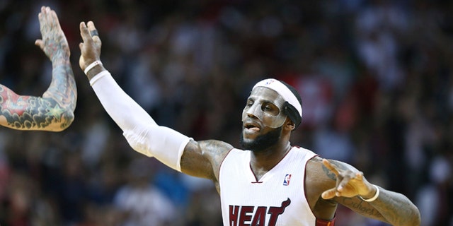 Miami Heat's LeBron James celebrates afer scoring two points with Chris Andersen during the second half of an NBA basketball game in Miami, Monday, March 3, 2014 against the Charlotte Bobcats. LeBron James scored a team recond of 61 points. The Heat won 124-107. (AP Photo/J Pat Carter)