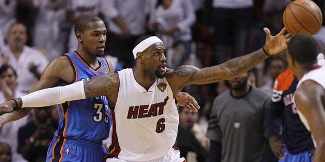 June 19, 2012: Miami Heat small forward LeBron James (6) reels in the ball as Oklahoma City Thunder small forward Kevin Durant (35) defends during the second half at Game 4 of the NBA Finals basketball series in Miami.