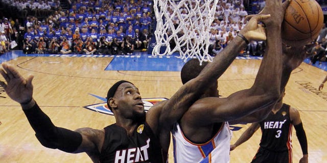 June 14, 2012: Miami Heat small forward LeBron James and Oklahoma City Thunder power forward Serge Ibaka (9) from Republic of Congo go after a loose ball during the first half at Game 2 of the NBA finals basketball series in Oklahoma City.