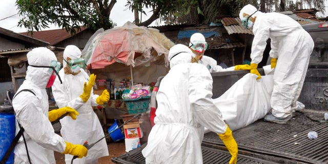 Sept. 10, 2014: Health workers load the body of a woman they suspect died from the Ebola virus onto a truck in Monrovia, Liberia.