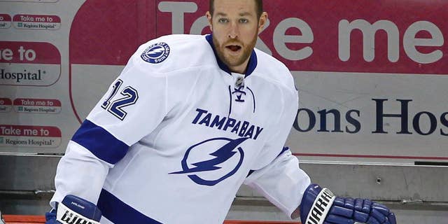 This Feb. 4, 2014 photo, Tampa Bay Lightning left wing Ryan Malone (12) stretches before an NHL hockey game against the Minnesota Wild in St. Paul, Minn. Malone was charged Saturday with DUI and possession of cocaine after a traffic stop, police said. An officer saw Malone's SUV strike a curb after making a left turn from the center lane early Saturday, said Tampa Police Lt. Paul Lusczynski. After being pulled over, Malone got out of his vehicle, and the officer smelled alcohol on his breath, Lusczynski said. According to the police report, the officer also found 1.3 grams of cocaine in one of Malone's pockets. Malone was released from the Hillsborough County jail on $2,500 bond. (AP Photo/Ann Heisenfelt)