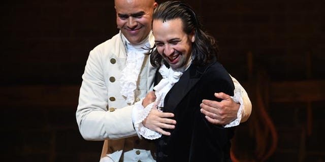 Actor and "Hamilton" creator Lin-Manuel Miranda, right, gets a hug from cast mate Christopher Jackson during his final performance curtain call at the Richard Rogers Theatre on Saturday, July 9, 2016, in New York. (Photo by Evan Agostini/Invision/AP)