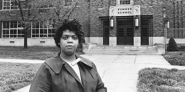 Linda Brown Smith stands in front of the Sumner School in Topeka, Kan., on May 8, 1964. The refusal of the public school to admit Brown when she was nine years old because she was black, led to the Brown v. Board of Education of Topeka, Kansas.