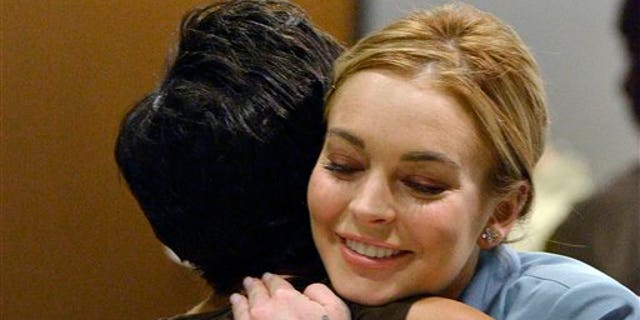 March 29, 2012: Lindsay Lohan, right, embraces her attorney, Shawn Chapman Holley after a progress report on her probation for theft charges at Los Angeles Superior Court.