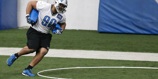 Detroit Lions defensive tackle Ndamukong Suh runs through drills during organized team activities at the Lions training camp facility in Allen Park, Mich., Wednesday, May 21, 2014. (AP Photo/Carlos Osorio)