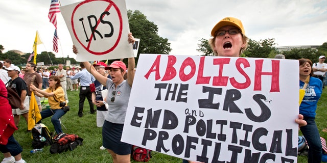 Tea party activists attend a rally on the grounds of the U.S. Capitol in Washington, Wednesday, June 19, 2013. The IRS has been under fire from Democrats and Republicans in Congress since May, when one of its officials publicly apologized for targeting conservative groups' applications for tax-exempt status for close examination. (AP Photo/J. Scott Applewhite)