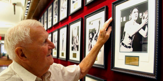 FILE - This Sept. 2, 2011 file photo shows Ray Lumpp, basketball gold medalist for the U.S. at the 1948 Olympics in London, pointing out his photo among those reserved for Olympic champions, at the New York Athletic Club. When the U.S. men's basketball team play Argentina on Friday night, the 89-year-old Lumpp promises to cheer louder than anyone else. (AP Photo/Bebeto Matthews, File)