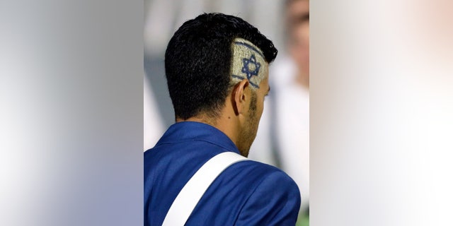 An Israeli athlete has his country's flag as a part of his a hairstyle during the Opening Ceremony at the 2012 Summer Olympics, Friday, July 27, 2012, in London. (AP Photo/Matt Slocum)