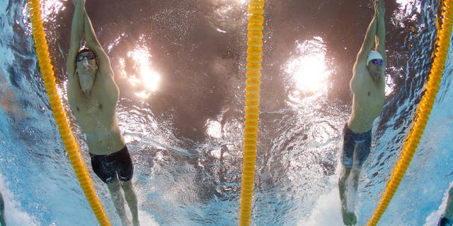 July 29, 2012: United States' Michael Phelps, left, and France's Fabien Gilot compete in the men's 4x100-meter freestyle relay final at the Aquatics Centre in the Olympic Park during the 2012 Summer Olympics in London.