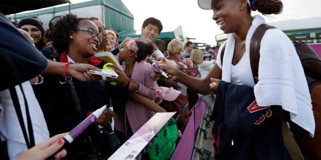 July 31, 2012: Venus Williams of the United States signs autographs after a doubles match at the All England Lawn Tennis Club in Wimbledon, London at the 2012 Summer Olympics.