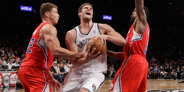 Los Angeles Clippers forward Blake Griffin, left,gets his hand on the ball as Brooklyn Nets center Brook Lopez, center, drives toward the basket with Clippers center DeAndre Jordan (6) also defending in the second half of an NBA basketball game at the Barclays Center, Thursday, Dec. 12, 2013, in New York. The Nets won 102-93. (AP Photo/Kathy Willens)