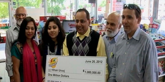 June 2012: This photo provided by WMAQ-TV in Chicago shows Urooj Khan, center, holding a ceremonial check in Chicago for $1 million as winner of an Illinois instant lottery game.