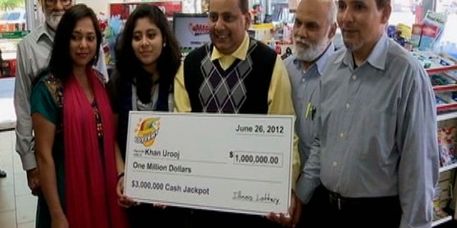 June 2012: This photo provided by WMAQ-TV in Chicago shows Urooj Khan, center, holding a ceremonial check in Chicago for $1 million as winner of an Illinois instant lottery game.