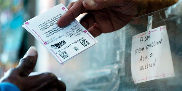 A person buys a Mega Millions lottery tickets at a newsstand in Philadelphia. No one matched all six numbers in Friday night's drawing.