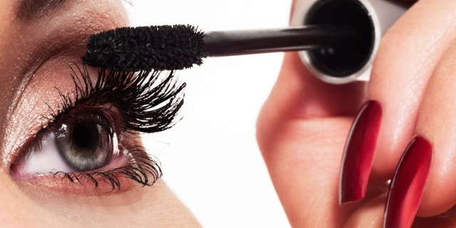 Woman eye with long eyelashes and mascara brush