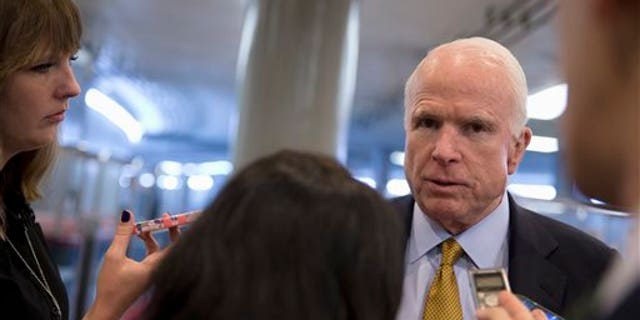 In this Oct. 20, 2015, photo, Senate Armed Service Committee Chairman Sen. John McCain, R-Ariz., talks to reporters near the subway on Capitol Hill in Washington. In the fight against the Islamic State group, members of Congress talk tough on extremism, but most want nothing to do with voting to legally authorize the military campaign, preferring to let the president take ownership of the mission. (AP Photo/Carolyn Kaster)