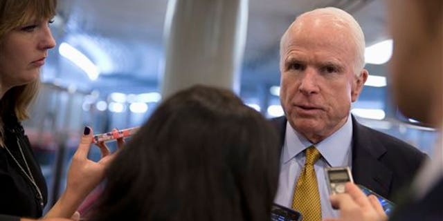 In this Oct. 20, 2015, photo, Senate Armed Service Committee Chairman Sen. John McCain, R-Ariz., talks to reporters near the subway on Capitol Hill in Washington. In the fight against the Islamic State group, members of Congress talk tough on extremism, but most want nothing to do with voting to legally authorize the military campaign, preferring to let the president take ownership of the mission. (AP Photo/Carolyn Kaster)