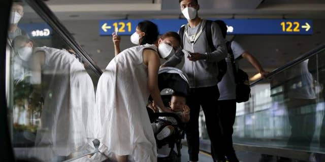 June 2, 2015: Passengers wearing masks to prevent contracting Middle East Respiratory Syndrome (MERS) ride on a travelator upon arrival at Incheon International Airport in Incheon, South Korea.