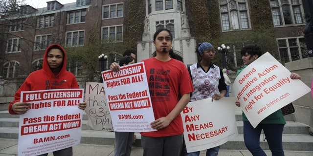 Jose Alvarenga, center, BAMN (By Any Means Necessary) national organizer, and others protest the Supreme Court ruling on the campus of the University of Michigan Tuesday, April 22, 2014, in Ann Arbor, Mich. The justices ruled 6-2 that Michigan voters had the right to change their state constitution in 2006 to prohibit public colleges and universities from taking account of race in admissions decisions. (AP Photo/Detroit News, David Coates ) DETROIT FREE PRESS OUT; HUFFINGTON POST OUT, MANDATORY CREDIT