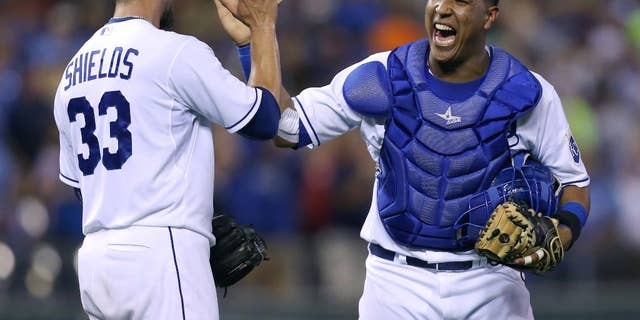 FILE - In this Aug. 9, 2014, file photo, Kansas City Royals catcher Salvador Perez celebrates with starting pitcher James Shields (33) after Shields threw a complete game shutout against the San Francisco Giants in Kansas City, Mo. After making the most starts behind the plate of any big league catcher in a century, Salvador Perez wants more. The Kansas City Royals star was among 29 players on the roster announced Friday, Nov. 7, 2014, for the Major League Baseball all-star postseason tour of Japan. (AP Photo/Ed Zurga, File)