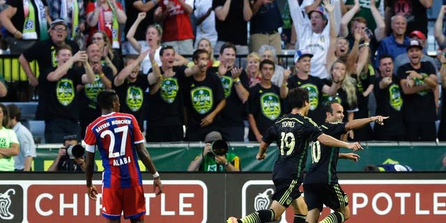 Los Angeles Galaxy forward Landon Donovan, right, celebrates with Chivas USA forward Erick Torres (19) as Bayern Munich's David Alaba (27) watches, after Donovan scored the go-ahead goal in the second half of the MLS All-Star soccer game, Wednesday, Aug. 6, 2014, in Portland, Ore. The MLS All-Stars won 2-1. (AP Photo/Ted S. Warren)