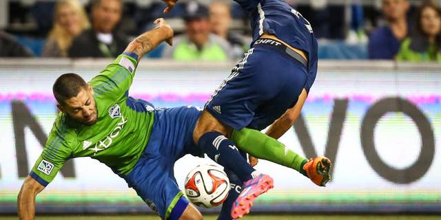 Seattle Sounders player Clint Dempsey tangles with a Vancouver Whitecaps player in the second half on Friday, October 10, 2014. The Whitecaps won the Cascadia Cup after beating the Sounders 1-0. (AP Photo/seattlepi.com, Joshua Trujillo)