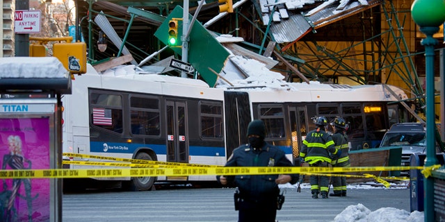 A Metropolitan Transportation Authority bus rests against scaffolding at 14th Street and 7th Avenue in New York, Wednesday, Feb. 12, 2014, after an early morning collision between the bus and a truck. One person was killed and at least four were injured in the crash, that also involved several parked vehicles. (AP Photo/Craig Ruttle)