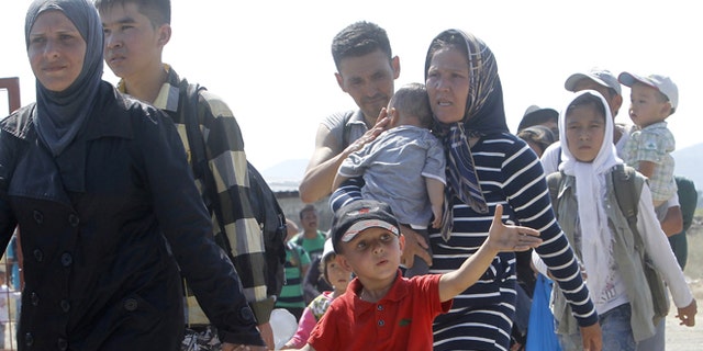 Aug. 31, 2015: A group of migrants with children arrive at the transit center for migrants, after crossing the border from Greece to Macedonia.
