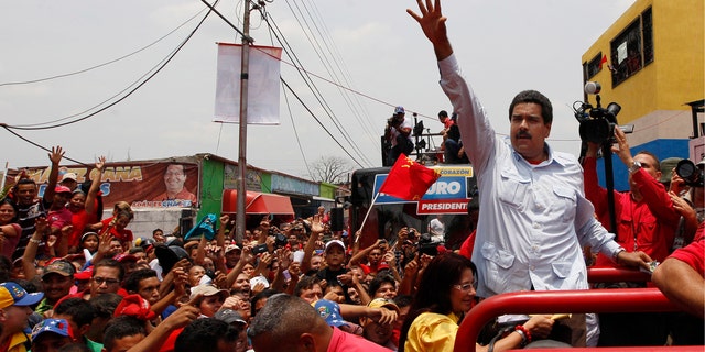 Venezuela's interim President Nicolas Maduro waves to supporters from the top of a vehicle as he campaigns in a caravan from Sabaneta to Barinas, in Sabaneta, Venezuela, Tuesday, April 2, 2013. A former union leader and bus driver, Maduro is competing against opposition leader Henrique Capriles in the April 14 presidential election.  Invoking the late President Hugo Chavez during a televised speech on Tuesday, Maduro declared: "This victory will belong to our commander!" (AP Photo/Ariana Cubillos)