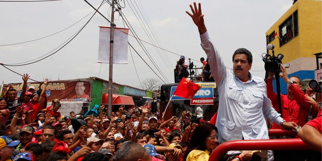 Venezuela's interim President Nicolas Maduro waves to supporters from the top of a vehicle as he campaigns in a caravan from Sabaneta to Barinas, in Sabaneta, Venezuela, Tuesday, April 2, 2013. A former union leader and bus driver, Maduro is competing against opposition leader Henrique Capriles in the April 14 presidential election. Invoking the late President Hugo Chavez during a televised speech on Tuesday, Maduro declared: "This victory will belong to our commander!" (AP Photo/Ariana Cubillos)