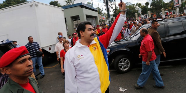 Venezuela's President Nicolas Maduro shows his inked finger after casting his vote during municipal elections in Caracas, Venezuela, Sunday, Dec. 8, 2013. Venezuelans head to the polls to elect mayors and city councilors at a moment when the country's economic troubles have deepened, with inflation touching a two-decade high of 54 percent, and shortages of everything from toilet paper to milk spreading while the black market value of the currency plunges. (AP Photo/Fernando Llano)