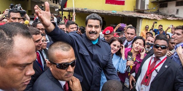 Venezuela's President Nicolas Maduro greets supporters before a ceremony at a monument in honor of the victims of the 1989 U.S. invasion, in the Chorrillo neighborhood which saw the heaviest fighting during the invasion, in Panama City, Friday, April 10, 2015. A crowd of several hundred chanted in Spanish, "Maduro, stick it to the Yankee!" (AP Photo/Ramon Espinosa)