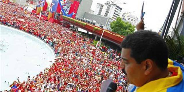 Venezuela's acting President, Nicolas Maduro, gestures to supporters after he registered as a candidate for president in the April 14th election outside the national election board in Caracas March 11, 2013. REUTERS/Carlos Garcia Rawlins