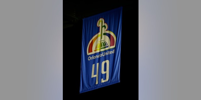 A banner printed with the names of the Pulse nightclub shooting victims and 49, the number of people who died in the shooting, is unveiled in the Amway Center during a tribute prior to an NBA basketball game between the Orlando Magic and the Miami Heat, Wednesday, Oct. 26, 2016, in Orlando, Fla. (AP Photo/John Raoux)