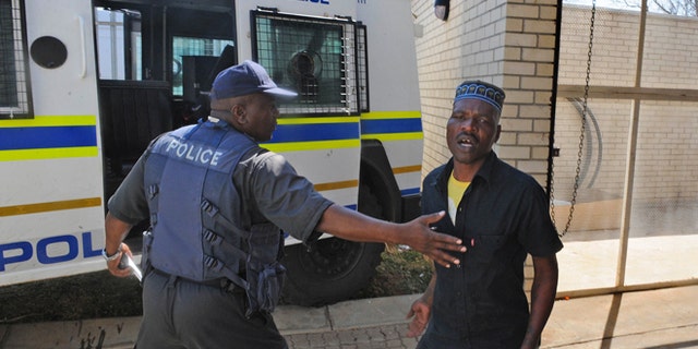 August 22, 2012: Chris Mahlangu, right, is led away from the court in Ventersdorp, South Africa after receiving a life sentence for the murder of right wing leader Eugene TerreBlanche.